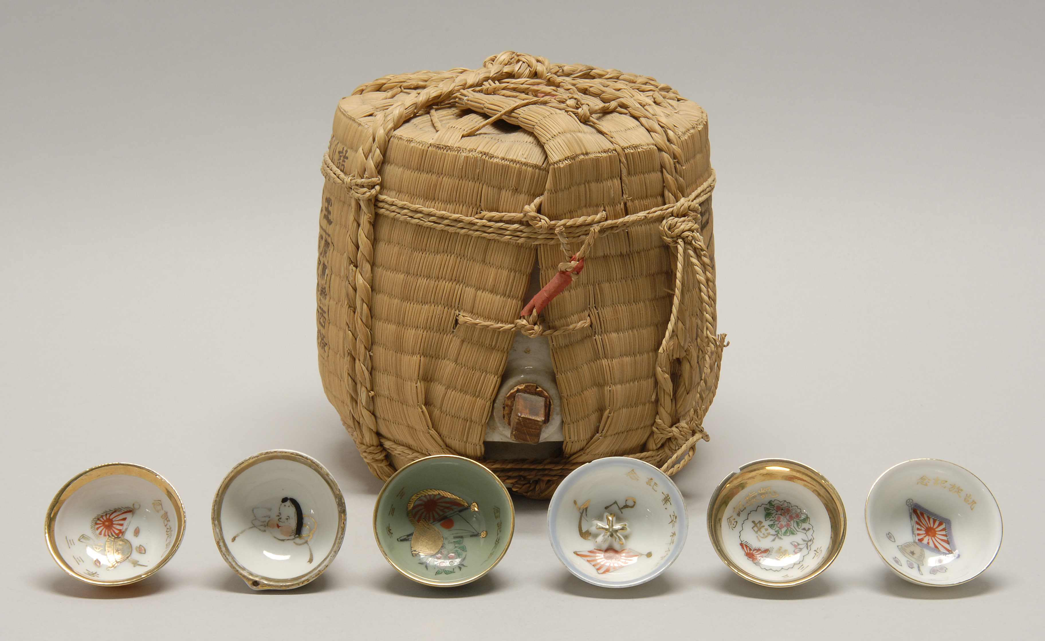 Appraisal: POTTERY SAKE BARREL ENCASED IN STRAW First Half of the