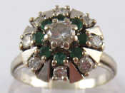 Appraisal: A white metal tests carat gold emerald and diamond cluster