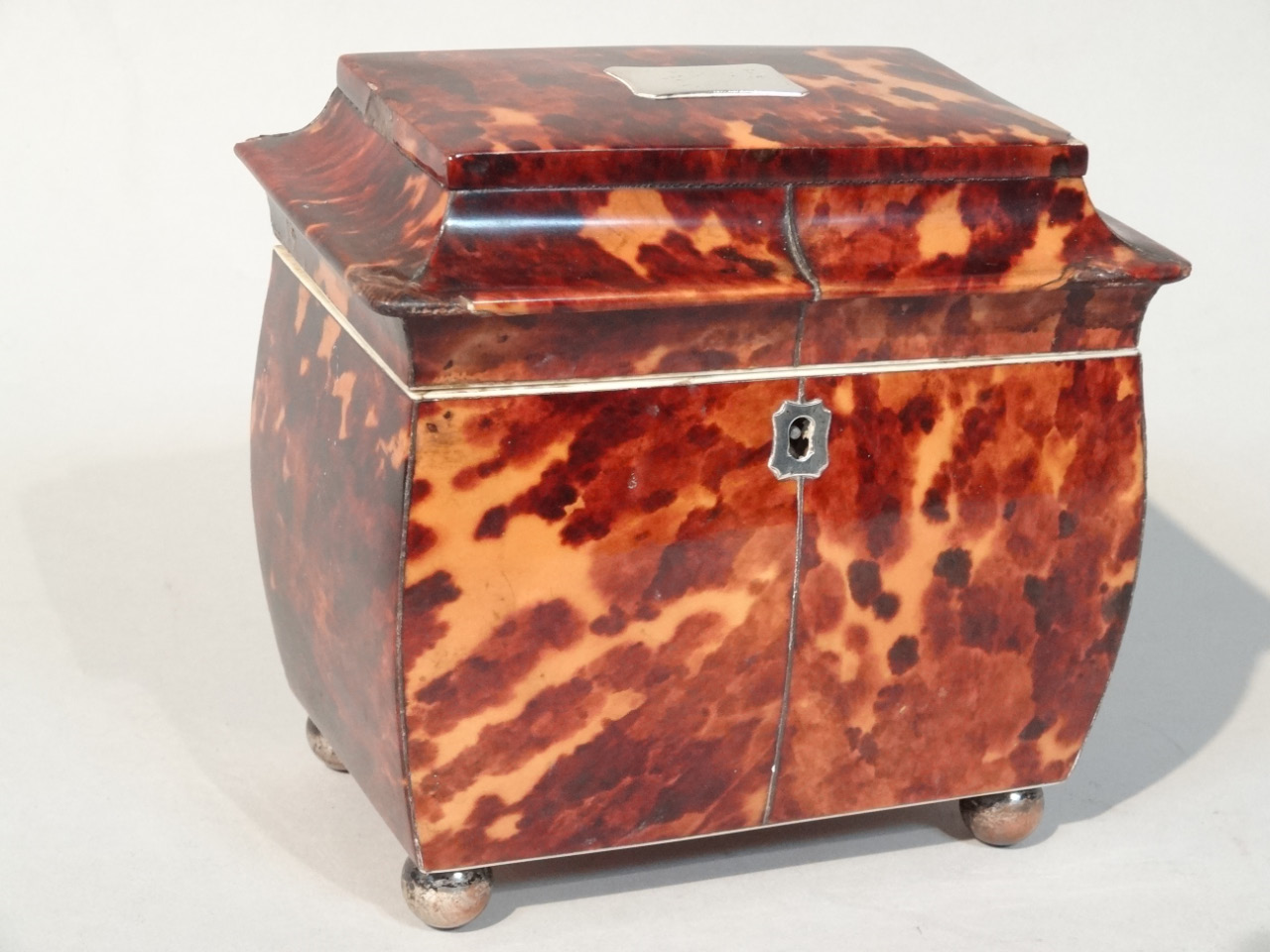 Appraisal: An early Victorian tortoiseshell bombe tea caddy the sarcophagus lid