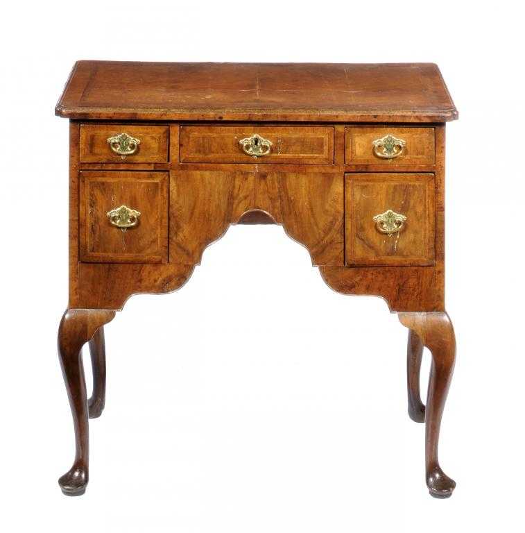 Appraisal: A WALNUT AND FEATHERBANDED LOWBOY the quarter veneered and moulded