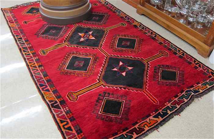 Appraisal: PERSIAN TRIBAL CARPET the red field filled with black diamond-shaped