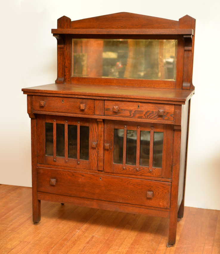 Appraisal: ARTS CRAFTS OAK SIDEBOARD Arched crest over shelf mirrored backsplash