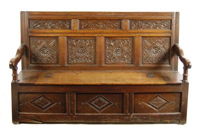 Appraisal: An oak settle the panelled back carved with flowers and