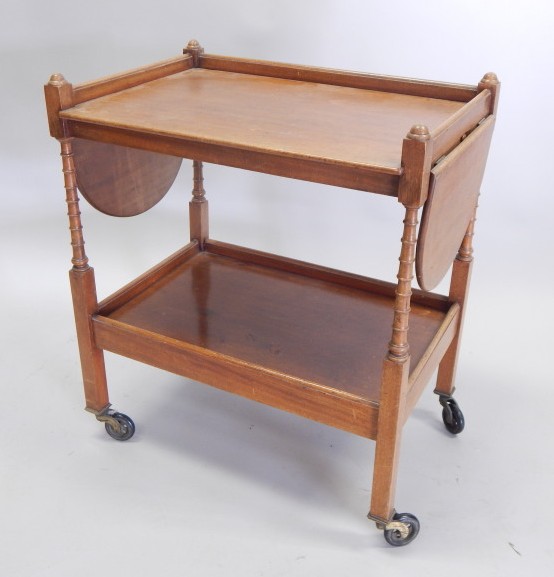 Appraisal: A thC mahogany drop leaf two tier trolley on spirally