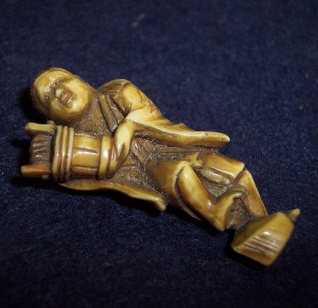 Appraisal: A Japanese ivory netsuke in the form of a man