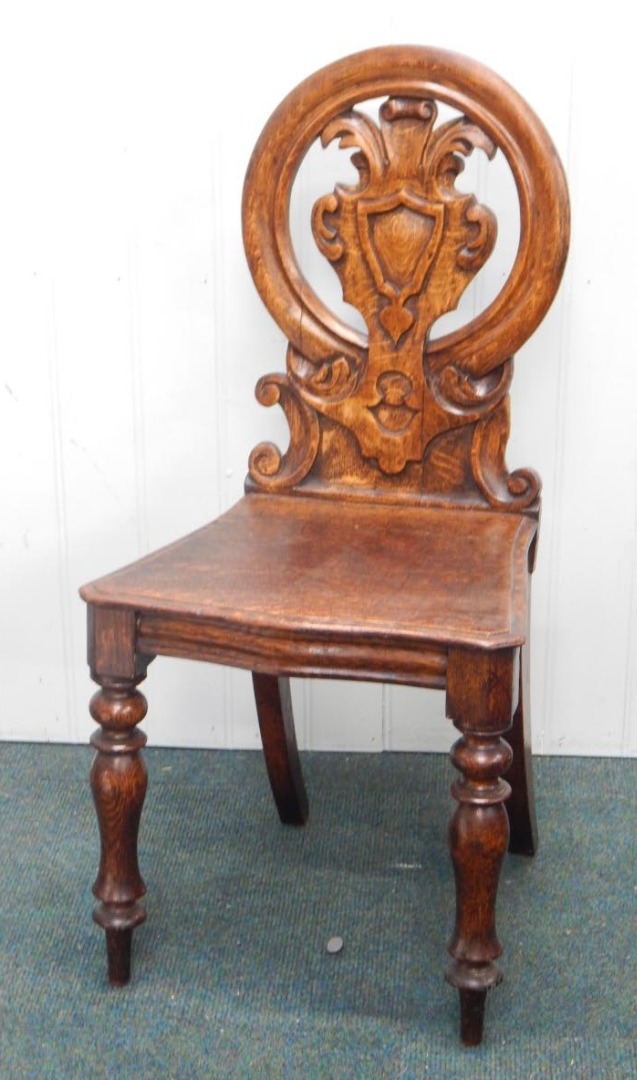 Appraisal: A Victorian oak hall chair the oval back carved with