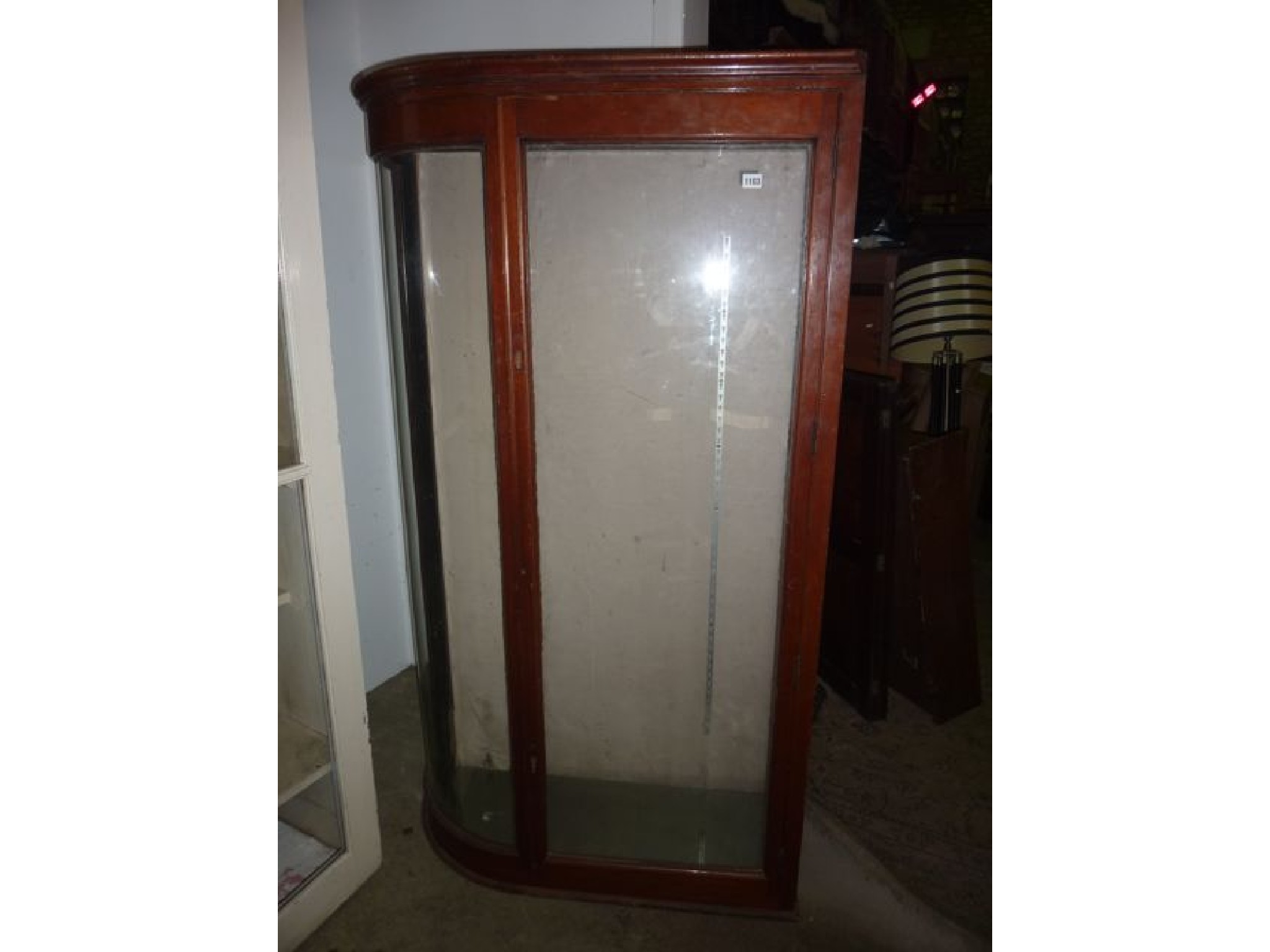 Appraisal: An Edwardian mahogany shop display cabinet enclosed by a single