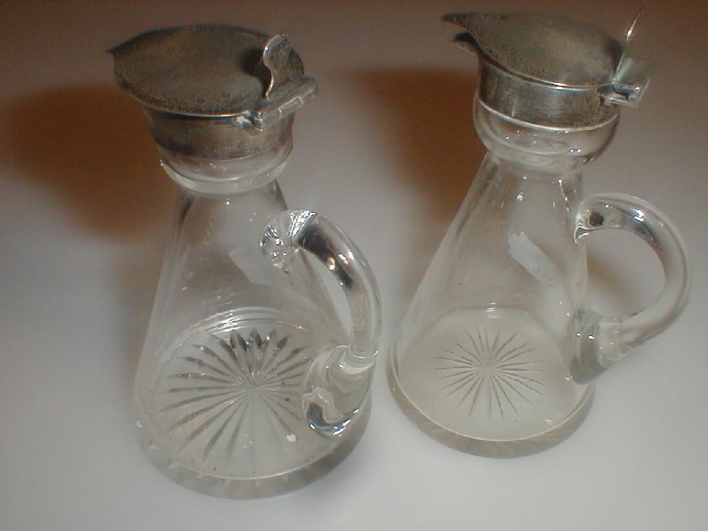 Appraisal: A pair of glass oil and vinegar jugs with silver