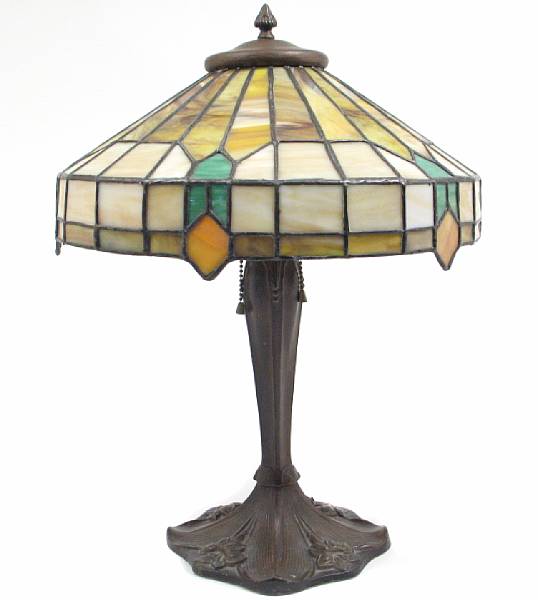 Appraisal: A patinated metal table lamp with leaded glass shade early