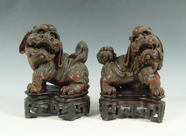 Appraisal: CHINESE CARVED WOOD FOO LIONS With remnants of gilt lacquer