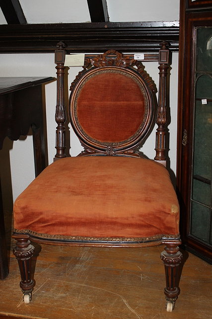 Appraisal: A VICTORIAN WALNUT NURSING CHAIR with circular back decorated with