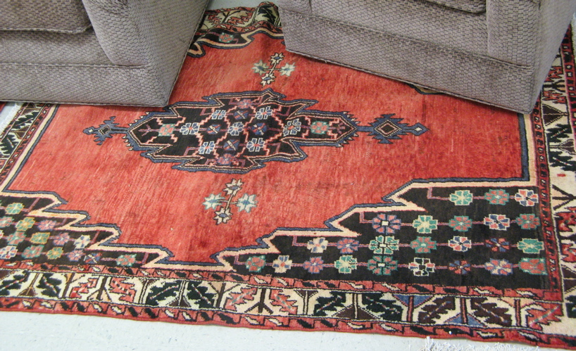 Appraisal: PERSIAN MASLAGHAN VILLAGE AREA RUG the plain red field centering