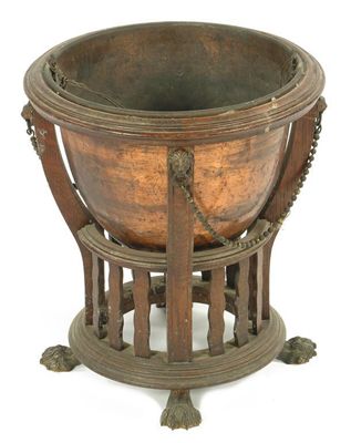 Appraisal: An Edwardian oak jardiniere with lift-out copper liner on paw