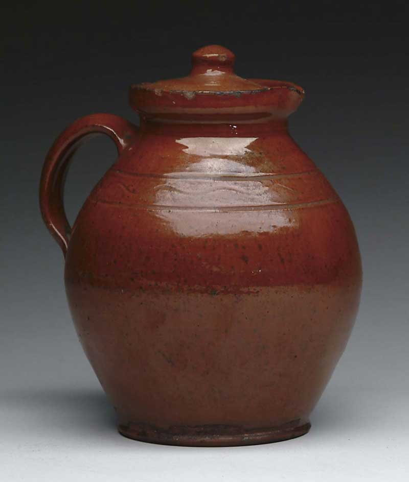 Appraisal: GOOD COVERED GLAZED REDWARE PITCHER Orange brown glaze with black