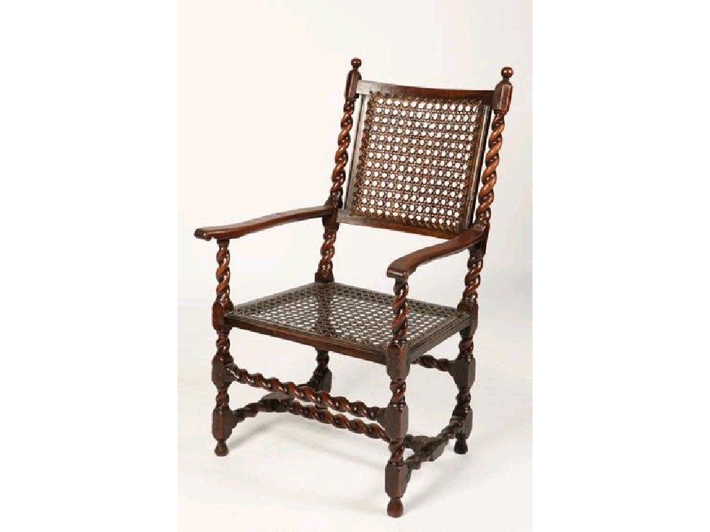 Appraisal: A CHARLES II WALNUT ARMCHAIR the caned back flanked by