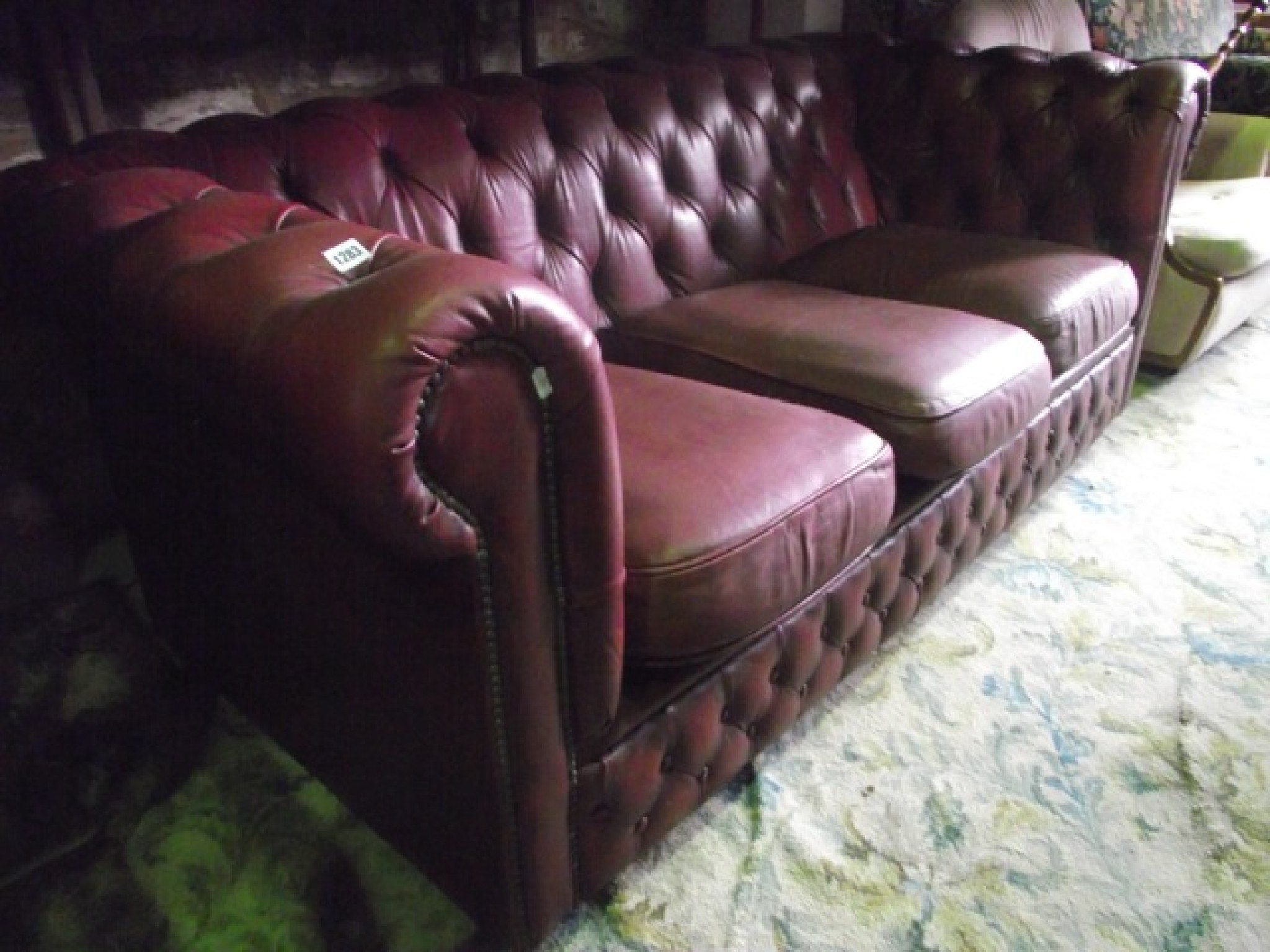 Appraisal: A three seat Chesterfield sofa with maroon leather upholstered finish