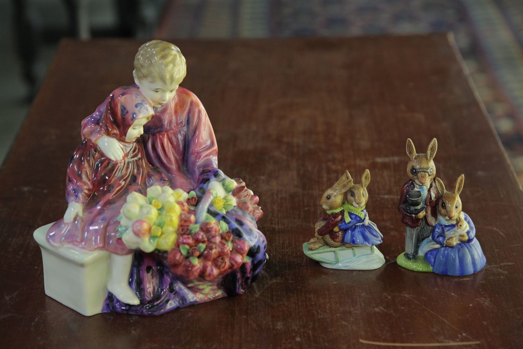 Appraisal: THREE ROYAL DOULTON FIGURES English th century Flower Sellers Children