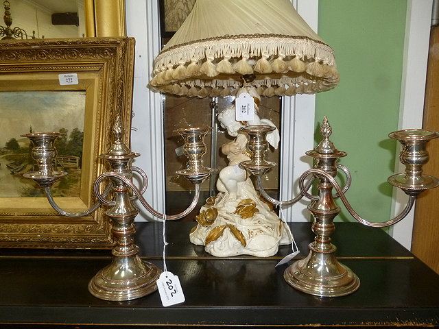 Appraisal: A PAIR OF SILVER PLATED TWO BRANCH THREE LIGHT CANDELABRA