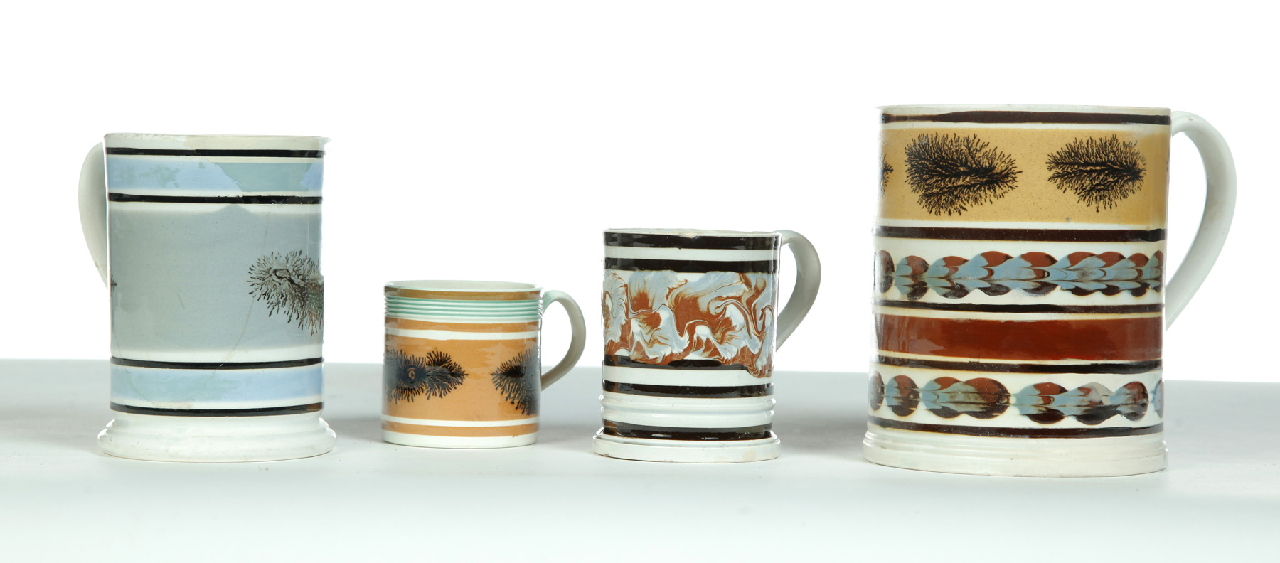 Appraisal: FOUR MOCHAWARE MUGS WITH DAMAGE AND RESTORATION England st quarter-