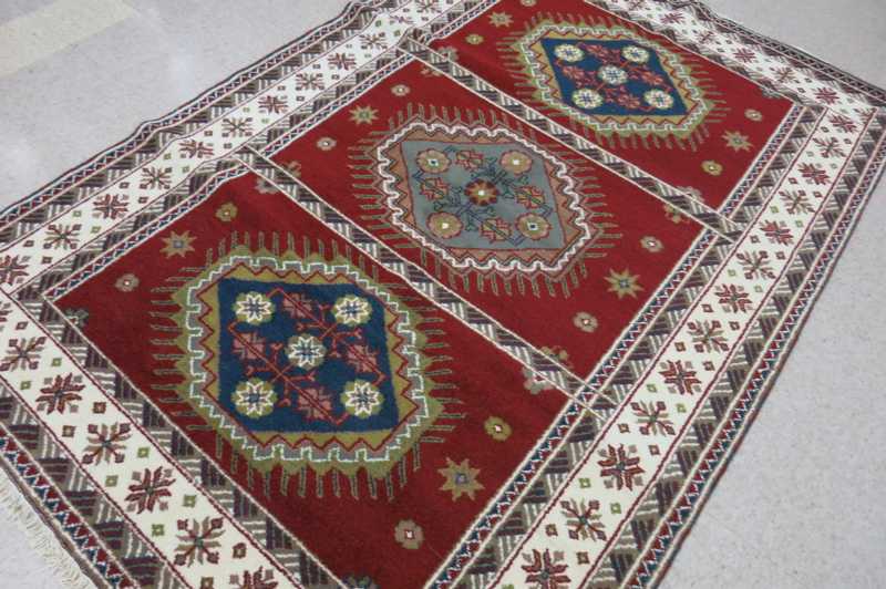 Appraisal: HAND KNOTTED ORIENTAL CARPET Indo-Kazak three geometric medallions design on