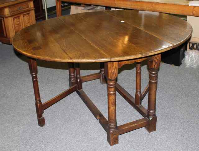 Appraisal: A REPRODUCTION GEORGIAN STYLE OAK DROP FLAP TABLE of oval