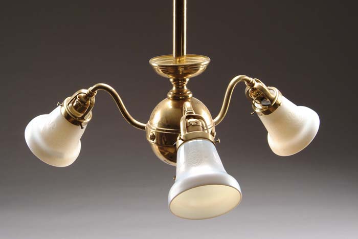 Appraisal: STEUBEN BRASS CHANDELIER Brass fixture supports three carved Ivorene shades