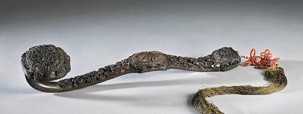 Appraisal: A wood ruyi scepter with dragon decoration Intricately carved with