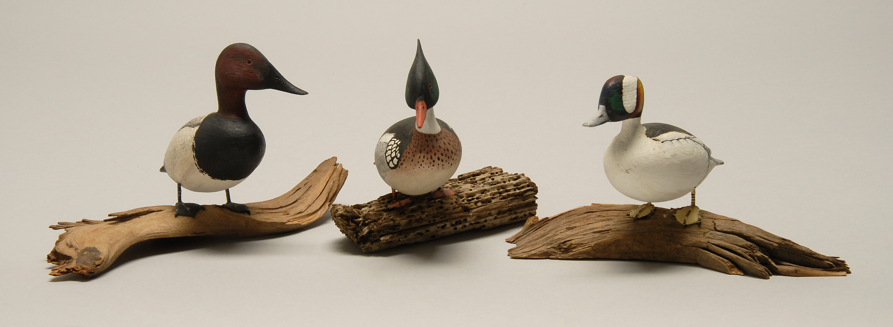 Appraisal: THREE MINIATURE BIRD CARVINGS A red-breasted merganser a bufflehead and