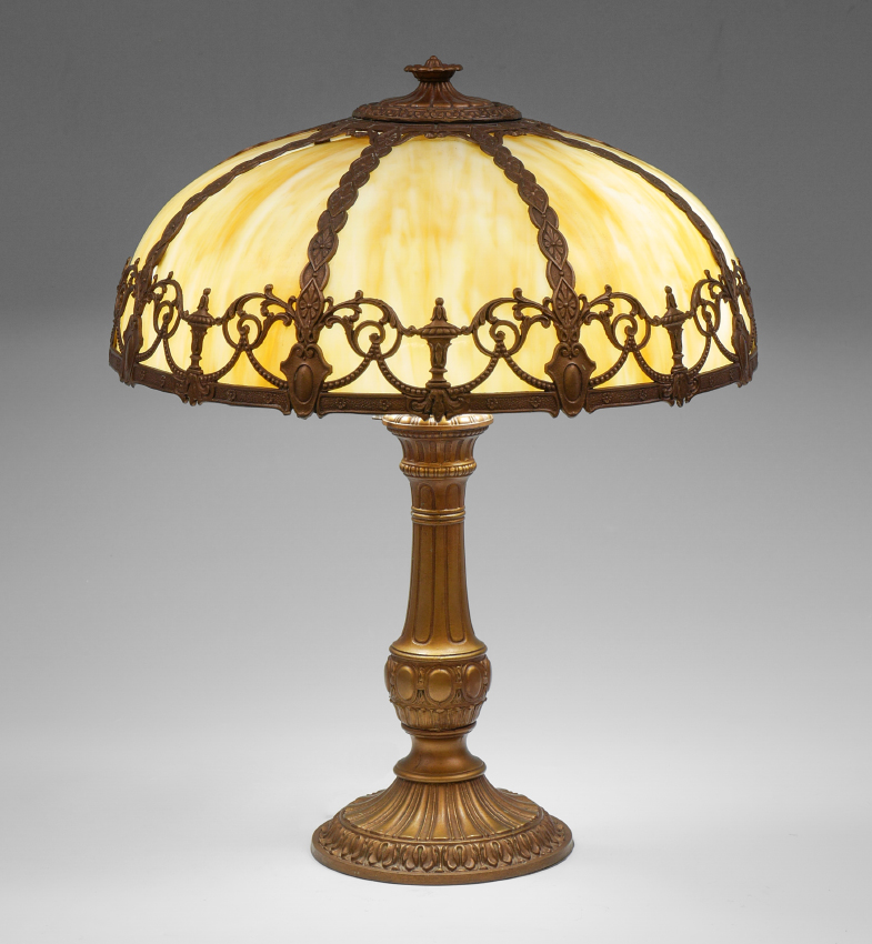 Appraisal: CARAMEL SLAG GLASS BENT PANEL LAMP Ornate patinated cast metal