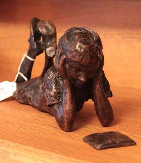 Appraisal: A CONTEMPORARY BRONZE SCULPTURE of a boy lying on his