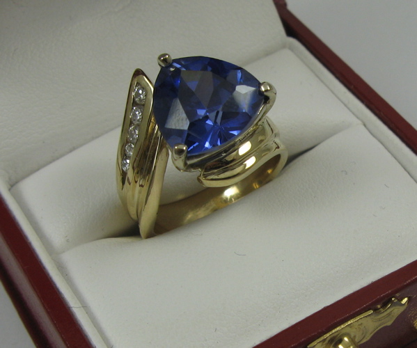 Appraisal: TANZANITE DIAMOND AND K GOLD RING set with a trilliant-cut