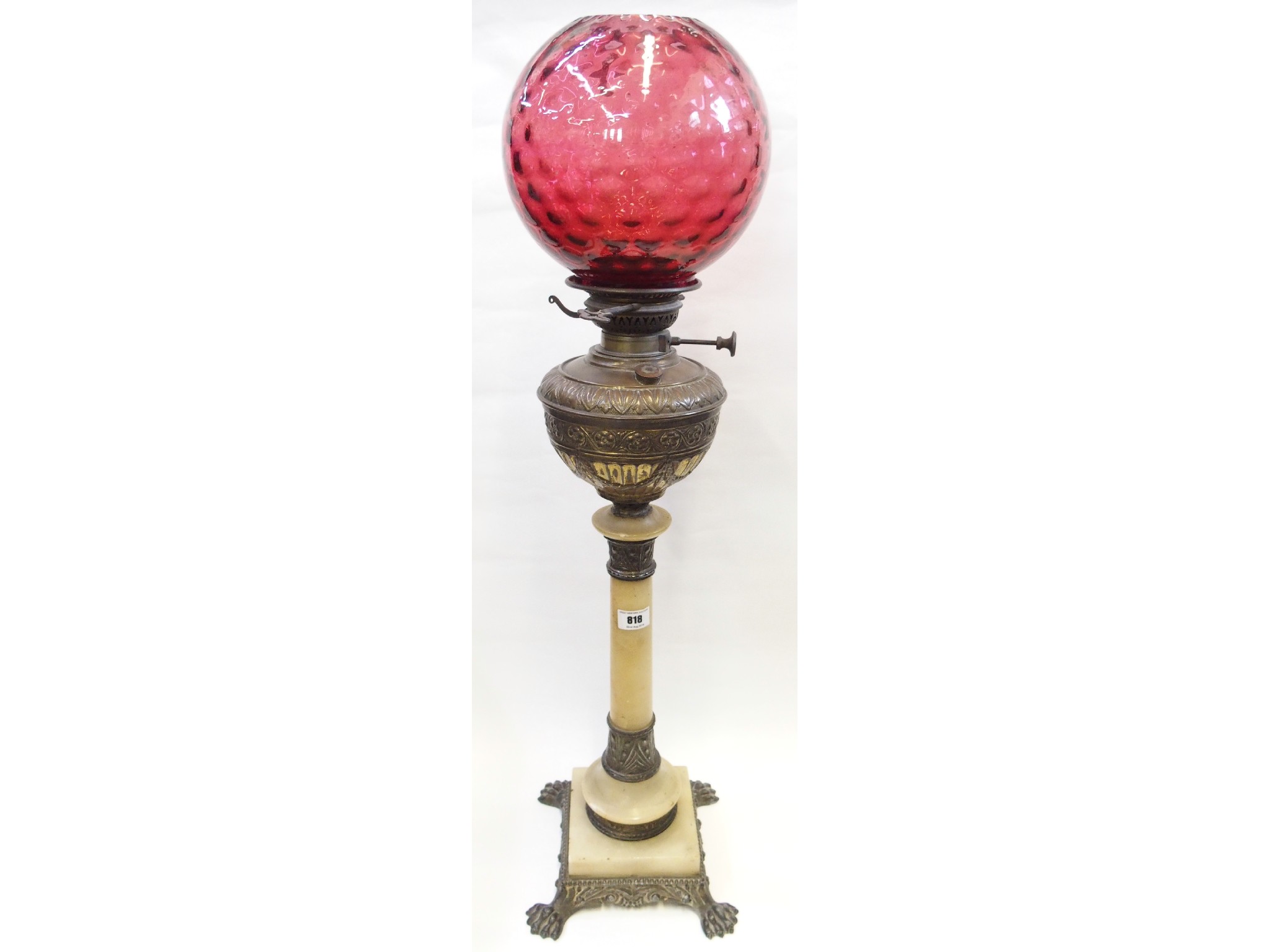 Appraisal: Onyx and patinated metal oil lamp with cranberry glass shade