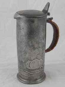 Appraisal: Archibald Knox A lidded cylindrical pewter jug with Art Nouveau