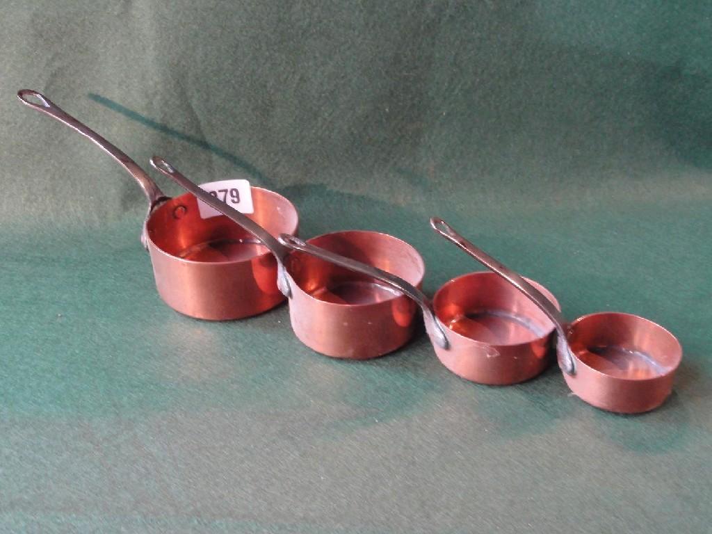 Appraisal: A set of four miniature graduated copper saucepans with iron