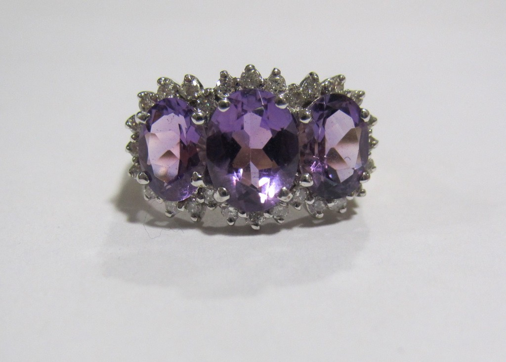 Appraisal: Nine carat gold amethyst and diamond cluster ring