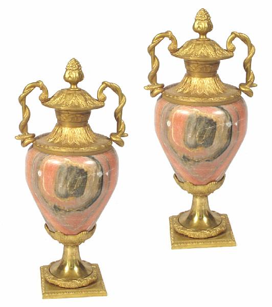 Appraisal: A pair of Neoclassical style pink marble urns with bronze