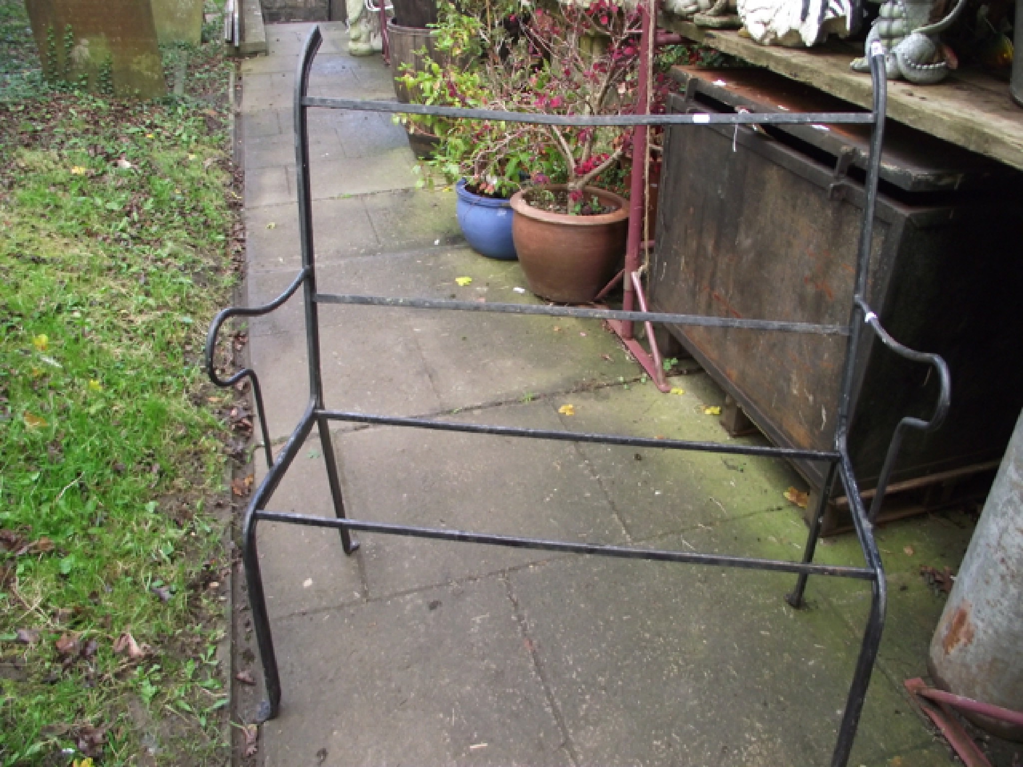 Appraisal: An ironwork two seat garden bench frame with shaped outline