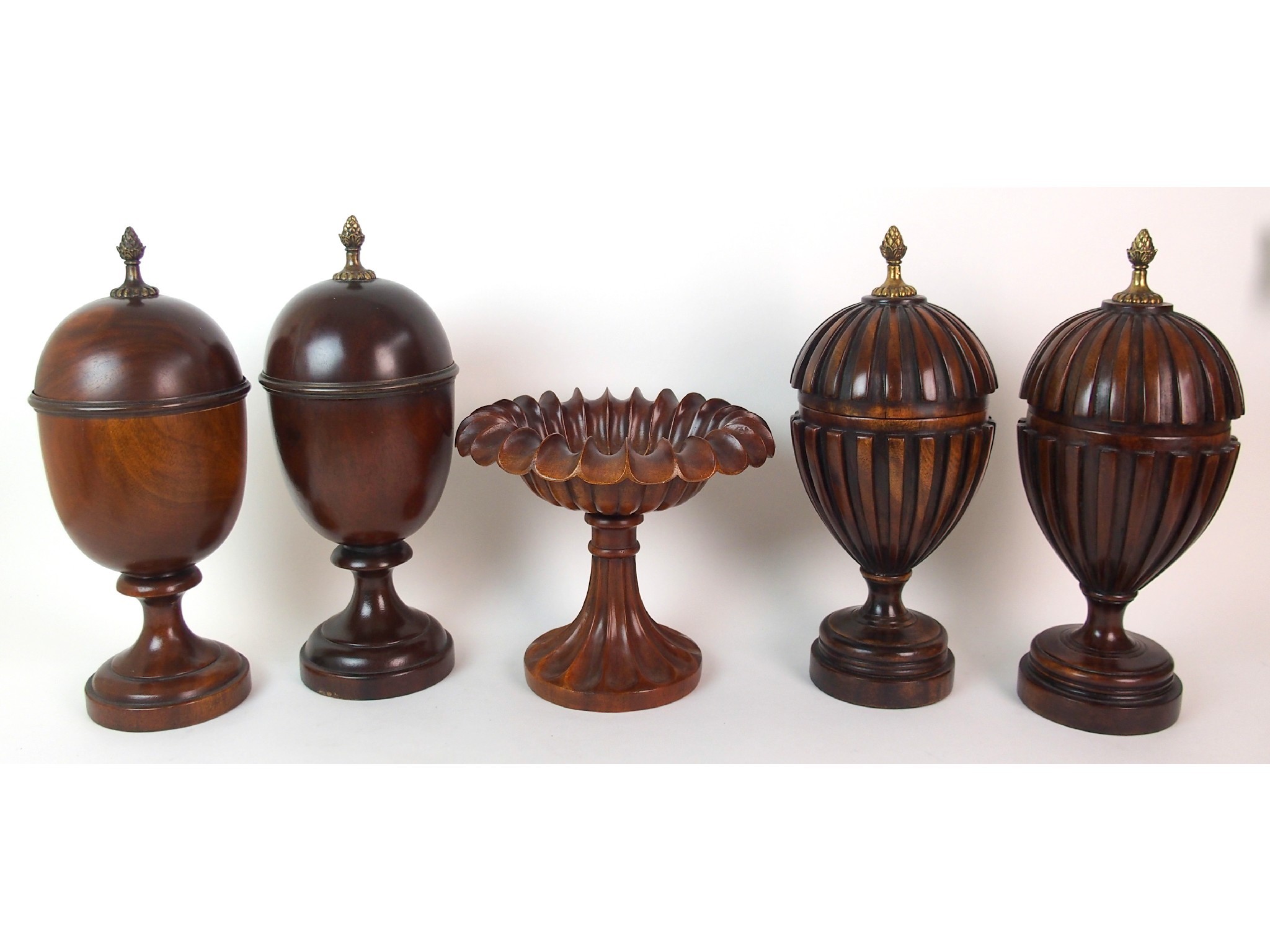 Appraisal: A pair of fluted mahogany urns and coverswith pineapple finials