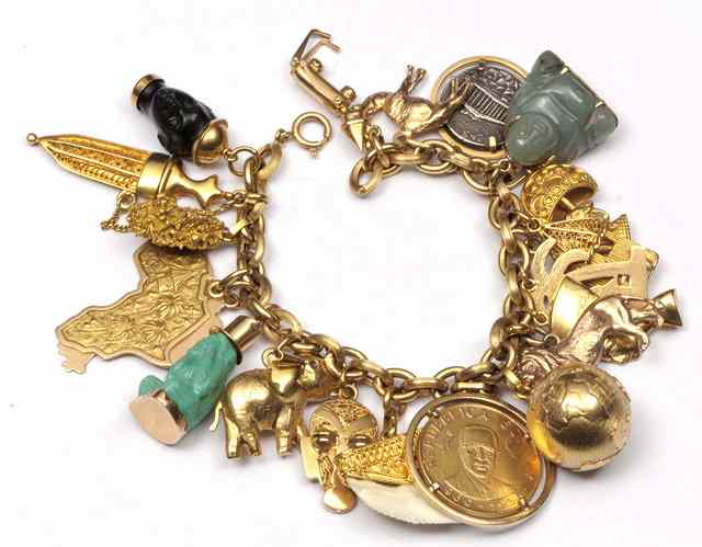 Appraisal: A GOLD CHARM BRACELET with twenty one attached charms in