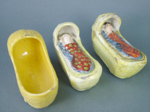 Appraisal: Three Staffordshire pottery models of cradles two with babies inside