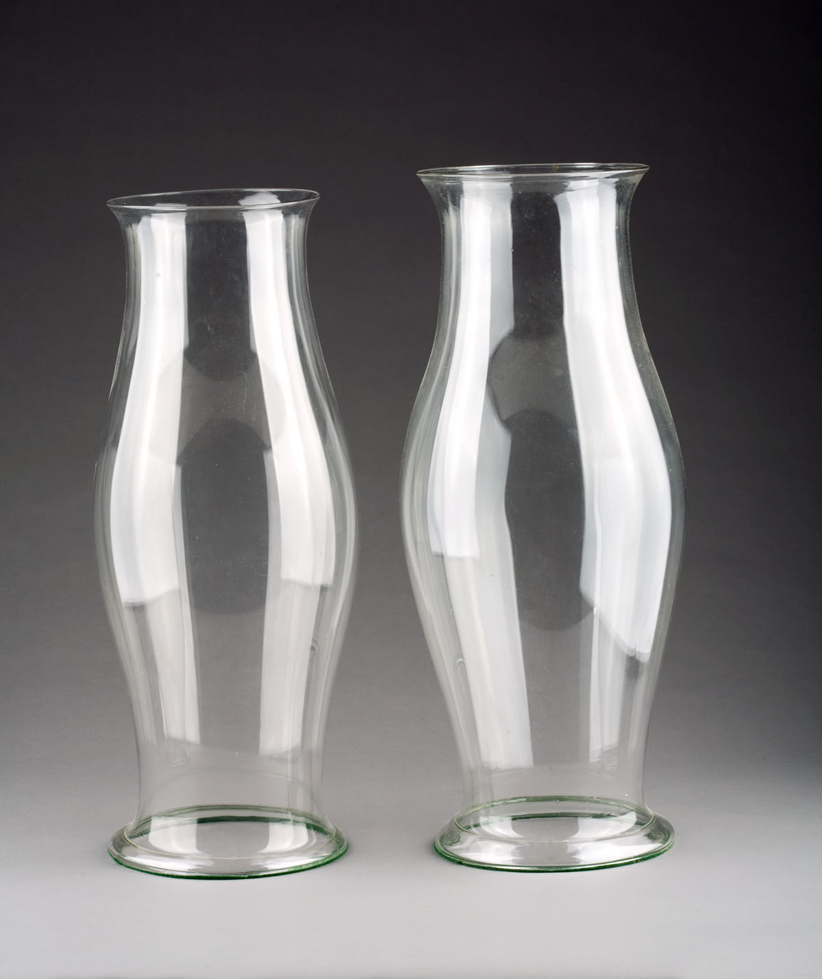 Appraisal: TWO MATCHING BLOWN GLASS HURRICANE SHADES WITH FOLDED OVER BASES