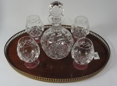 Appraisal: A cutglass branded decanter with glasses on a wooden brass