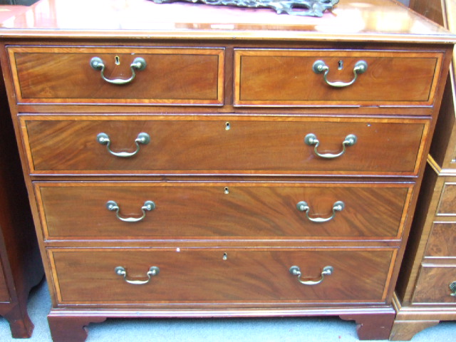 Appraisal: A th century crossbanded mahogany chest of two short and