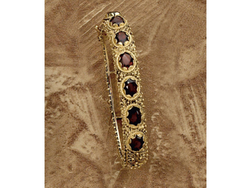 Appraisal: GARNET BRACELET k yellow gold bangle bracelet with seven oval