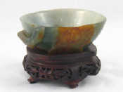 Appraisal: A Chinese jade bowl carved as a hollowed peach on