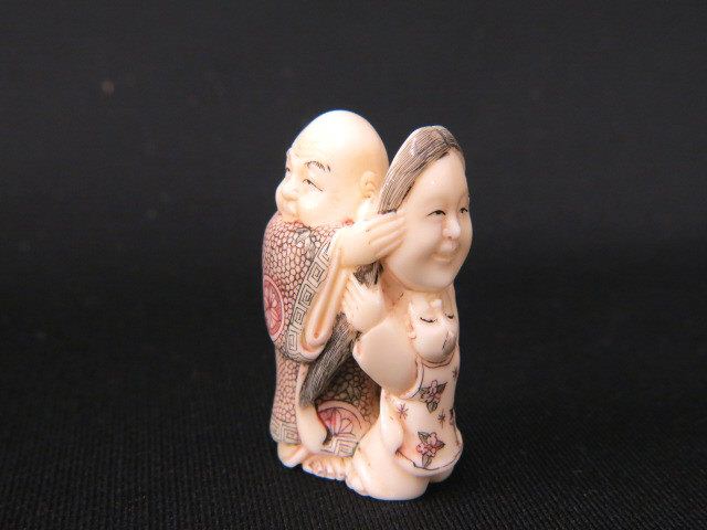 Appraisal: Carved Ivory Netsuke of a Manholding a mask child by