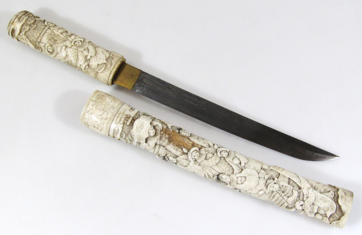 Appraisal: A thC Japanese bone cased tanto dagger with heavily carved