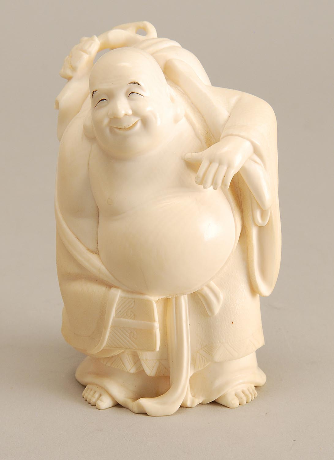 Appraisal: IVORY FIGURE OF HOTEI Late Meiji PeriodIn standing position carrying