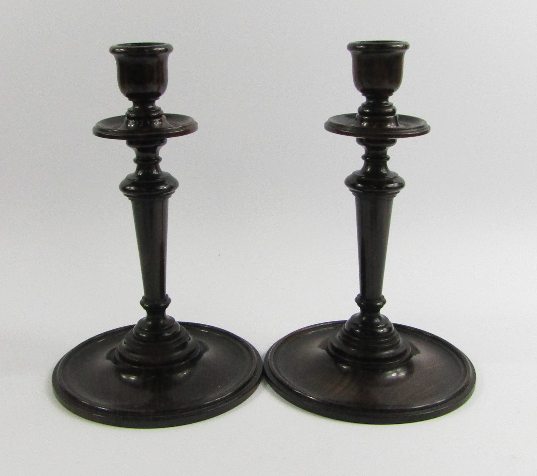 Appraisal: A pair of early thC turned lignum vitae candlesticks cm