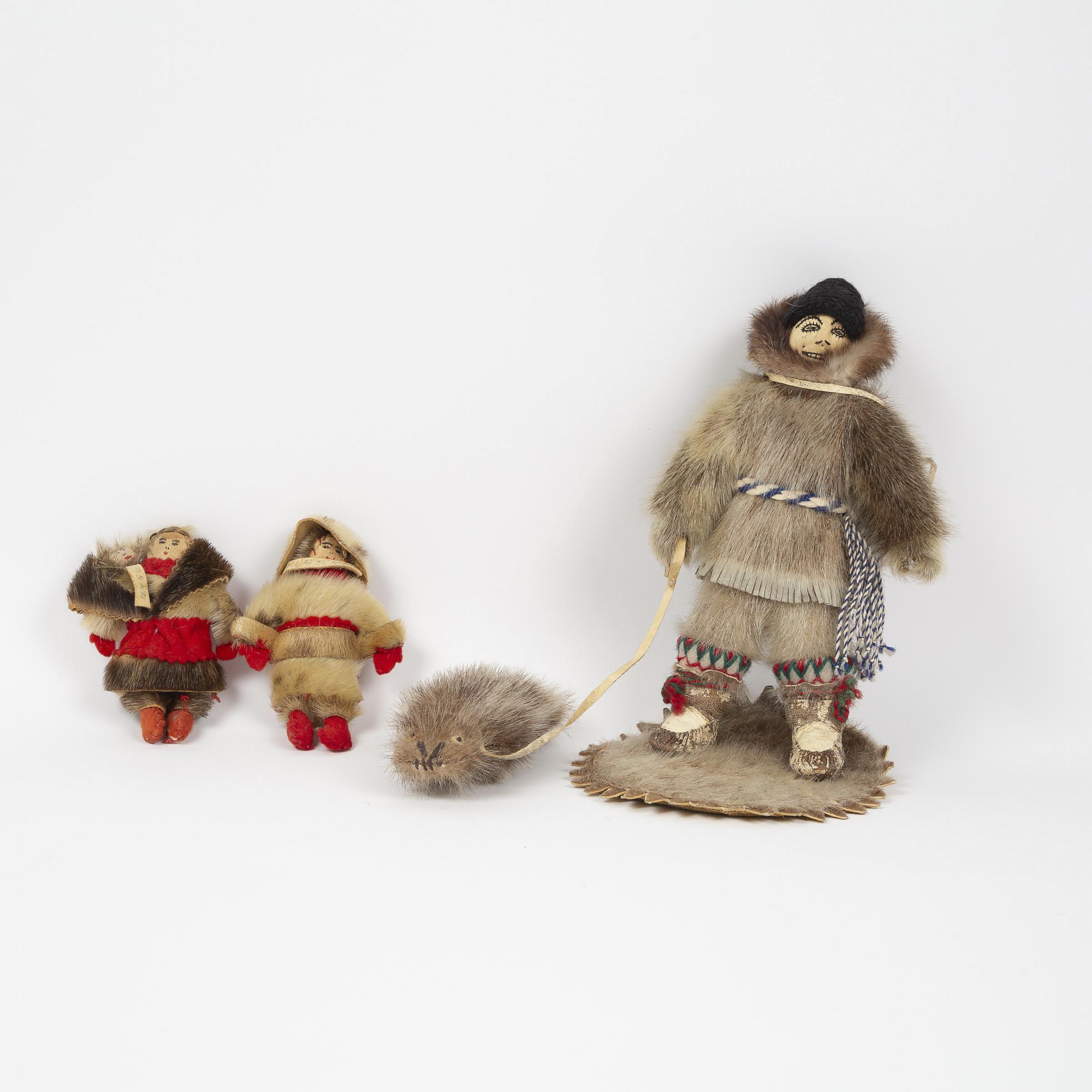 Appraisal: UNIDENTIFIED ARTIST HUNTER HAULING A SEAL AND TWO SMALL DOLLS